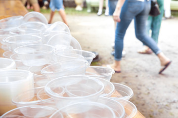 Empty plastic plates on the background of people. The concept of environmental pollution.