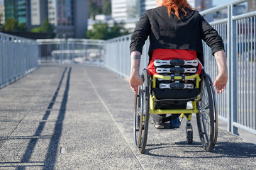 Obraz premium Young woman in wheelchair on a bridge