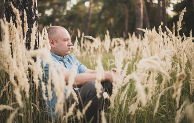 a man in the field in the grass at sunset