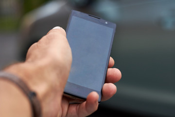 A man's hand holding a smartphone.