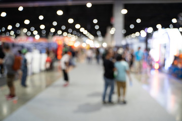 Blurred images of trade fairs in the big hall. image of people walking on a trade fair exhibition...