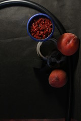 bowl with tobacco for hookah. fruits on a black background