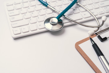 Doctor diagnoses concept - stethoscope on computer keyboard with medical record case and pen on...