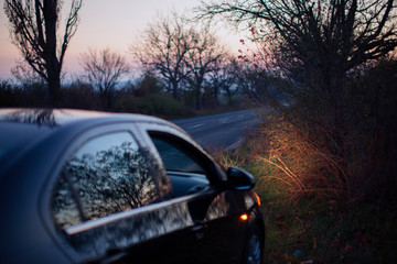 Obraz premium Black car on the road in the dusk