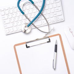 Doctor diagnoses concept - stethoscope on computer keyboard with medical record case and pen on white working table. Top view, flat lay, copy space
