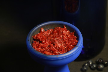bowl with tobacco for hookah. fruits on a black background