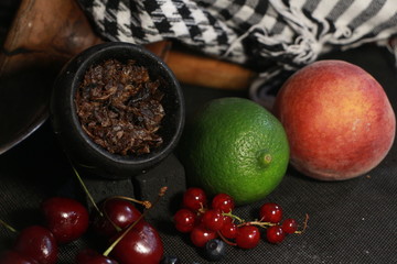 bowl with hookah tobacco. berries on a black background. nargile smoking
