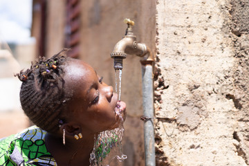 Healthy Fresh Water drips from Tap into African Child's Mouth