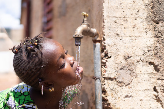 Healthy Fresh Water drips from Tap into African Child's Mouth