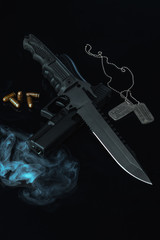 Obraz na płótnie Canvas Solders combat knife smoke and gun on black background