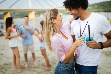 Smiling happy couple having fun on the beach. Holidays, vacation, love and friendship concept