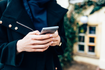 Young woman dressed in elegant black coat