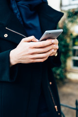 Close-up young woman dressed in elegant black coat