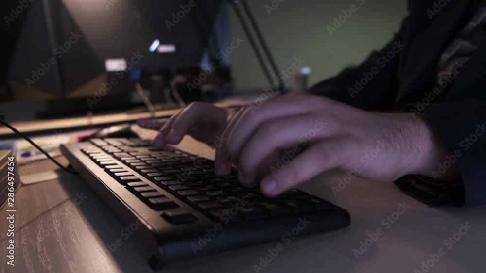 Poster close-up of hacker typing on keyboard. stock footage. programmer quickly typing code or text on comp