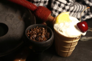 bowl with tobacco for hookah. berries on a black background