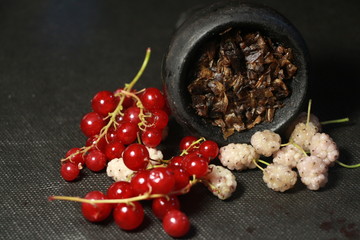 bowl with tobacco for hookah. fruits on a black background