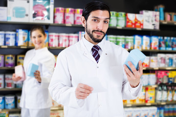 Pharmacist holding medicines in drugstore