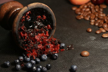 bowl with tobacco for hookah. fruits and berries on a black background. smoke hookah © Serhiy