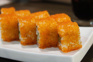 Japanese orange sushi on a white plate