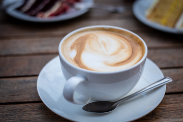 Cup of fresh aromatic cappuccino  coffee and delicious dessert sweets