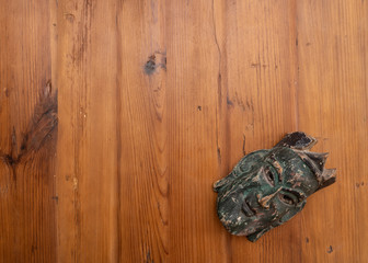 green mask on the old wooden texture