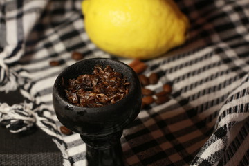 bowl with tobacco for hookah. fruits and berries on a black background. smoke hookah