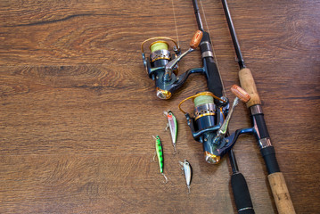 Fishing tackle - fishing spinning, hooks and lures on darken wooden background