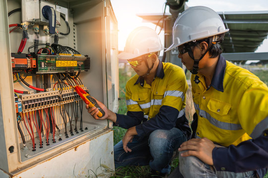 Workers use clamp meter to measure the current of electrical wires produced from solar energy for confirm to normal current