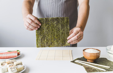 Person holding sushi nori