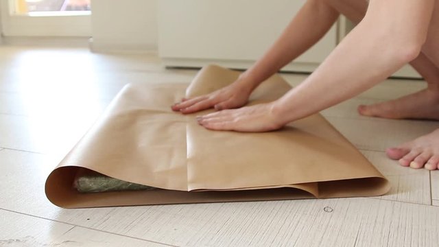 Female hands wrap a gift in craft gift paper. Preparation for a new year, birthday or christmas
