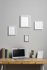 Wooden desk with laptop and photo frames