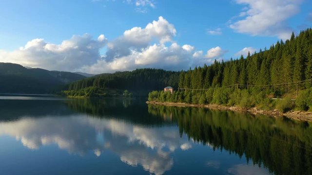 evening lake aerial panorama with the beautiful reflections and pine forest coastline