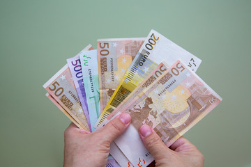 The hands close-up of a man are holding euro banknotes