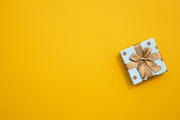 Minimalistic wrapped gift on yellow background