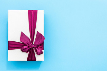 Full wrapped gift with ribbon blue background