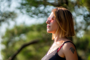 Mid aged happy woman is practising yoga in forest.