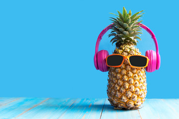 Summer in the party.  Hipster Pineapple Fashion in sunglass and music bright beautiful color in holiday, Creative art fruit for tropical style on the beach vibes, blue background.  Fashion Summer  - obrazy, fototapety, plakaty