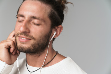Fototapeta premium Close up of a smiling young man enjoys listening to music