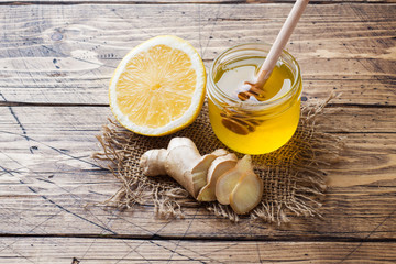 Lemon honey and ginger root on wooden background with copy space. Ingredients for a tonic vitamin...