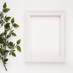 Wooden frame near the twigs on white backdrop