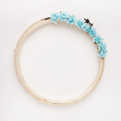 Blue roses on the wooden circular border frame on white backdrop