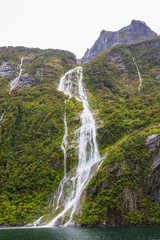 Running waterfall stream down mountainside.