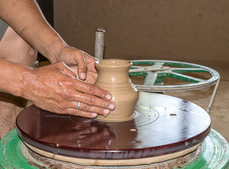 Making a jug of clay by hand on a potter's wheel. A gunner makes a jug of clay. A folk craft