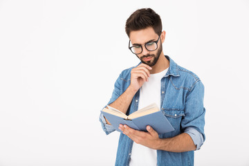 Image of serious smart man wearing eyeglasses holding and reading book