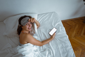 woman sleeping in sleep mask smartphone near her