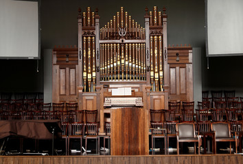 Wooden stage, alter, and pipe organ inside an old church.
