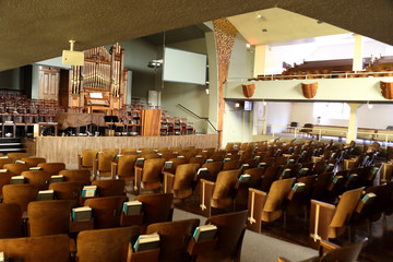 Wooden stage, alter, and pipe organ inside an old church.