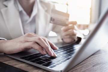  Online payment, Young Man's hand using computer laptop and hand holding credit card  for online shopping.