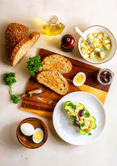 Open sandwich with traditional German potato salad, bread, all ingredients on wooden cutting board, top view
