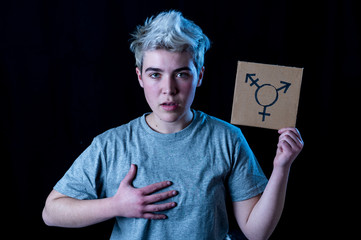 Portrait of happy proud and confident trans teenager man holding transgender symbol